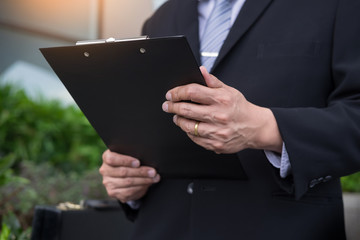  businessman holding a clipboard for working in outdoor