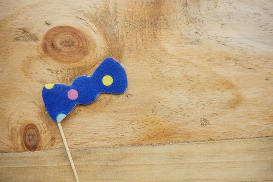 Top or flat lay view of Photo booth props a blue polkadot bow tie on a wooden background flat lay. Birthday parties and weddings.
