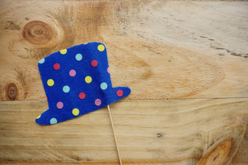Top or flat lay view of Photo booth props a blue polkadot hat on a wooden background flat lay. Birthday parties and weddings.