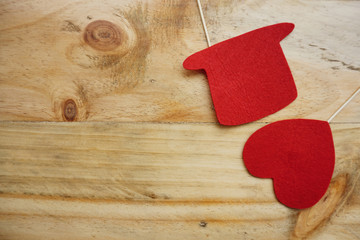 Top or flat lay view of Photo booth props a red heart shape and a red hat on a wooden background flat lay. Birthday parties and weddings.