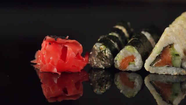 Close-up of a row of sushi on a black background. Japanese food.