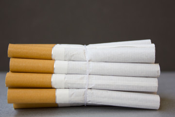 the group of cigarettes wrapped over a gray background