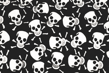 Color print on cotton fabric. White skulls and bones on a black background