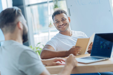 Handsome cheerful man looking at his colleague