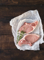 Two raw steaks on wooden table, top view