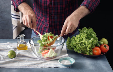 Man cooking salad In the home kitchen