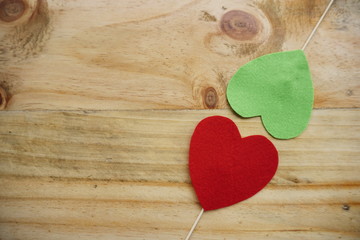 Top or flat lay view of Photo booth props a red heart shape and a green heart on a wooden background flat lay. Birthday parties and weddings.