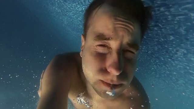 Man Swimming Underwater Breathing Out Air Slow Motion