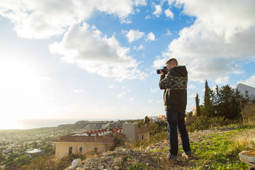 Travel, vacation, photographer and hitchhiker concept - traveler man photographed nature