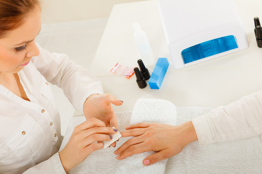 Woman making manicure using nail polish remover