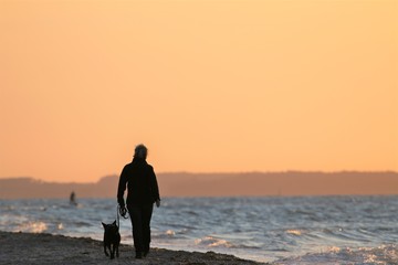 Fototapeta premium Frau mit Hund am Strand 