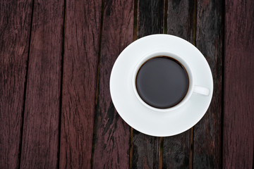 A white coffee cup on wooden table in the garden, Black coffee on wooden background, coffee break in the morning, relaxing and refreshing concepts.