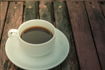 A white coffee cup on wooden table in the garden, Black coffee on wooden background, coffee break in the morning, relaxing and refreshing concepts.