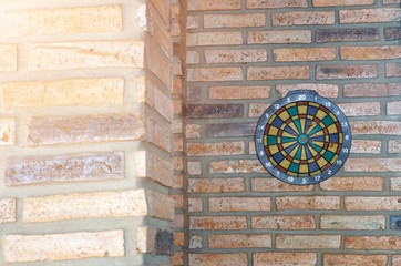 dart arrow missing the center of target. dartboard on brick wall with sunrise. business and marketing concept.