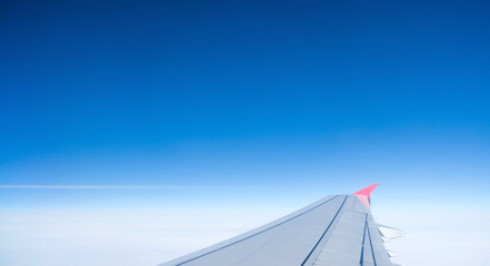 Wing of an airplane flying above the clouds.