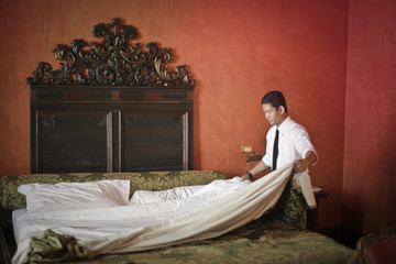 Preparing a bed in a luxury hotel room