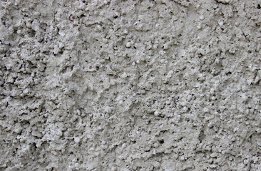 rough gray background wall with protruding portions of porous