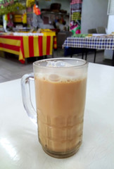 Teh tarik or pulled tea is a famous sweet milk tea in Malaysia. Bubble is floating on the surface of teh tarik.