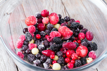 Frozen berries in a glass bowl, closeup