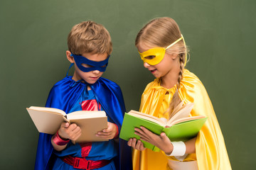 pupils in superhero costumes with books