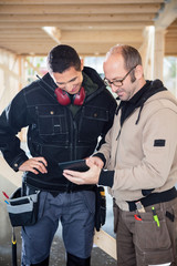 Carpenters Using Digital Tablet At Site