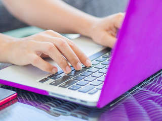 Closeup female hands typing on laptop keyboard. Woman working at home office concept.