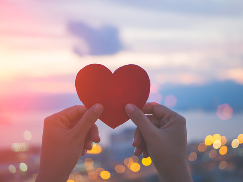 Naklejka Soft focus hand holding beautiful heart during sunset background. Happy, Love, Valentine's day idea, sign, symbol, concept.