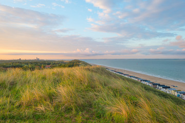 Fototapeta premium Sand dunes along a sea at sunrise in summer