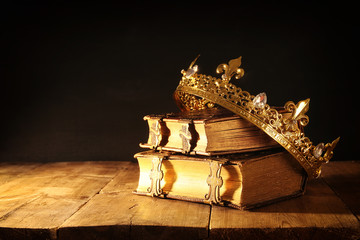 low key of beautiful queen/king crown on old books. vintage filtered. fantasy medieval period