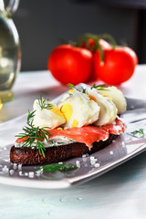 sandwich with ricotta cheese, salmon and poached egg on a plate