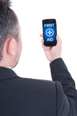 Male holding smartphone with first aid text