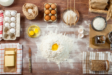 Egg yolk in flour on a wooden table in a bakery. Rural or rustic style. Top View