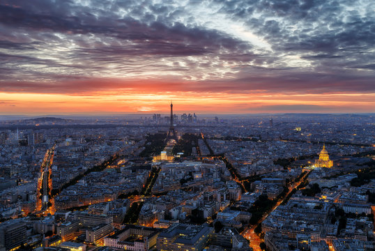 Scenic sunset sky over Paris, France. Aerial panorama view with the Eiffel Tower and the Invalides in the background. Colourful nighttime skyline. Travel background.