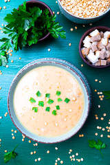 Pea soup in green bowl on green wooden background. Top view. Dry yellow pea. Vegan food.