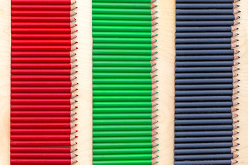 composition à partir de crayons de couleur rouge, vert et noir rassemblés en bande et alignés