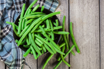 Raw green beans in a black dish