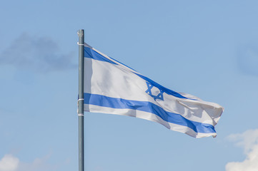 The National flag of Israel flay over the blue sky