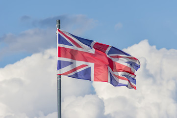 The National flag of United Kingdom flay over the blue sky