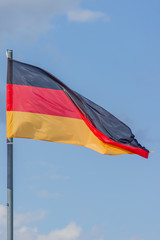 The National flag of Germany flay over the blue sky
