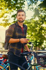 A man using a smart phone near bicycle parking.