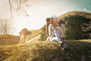 Happy couple outdoor. Couple sitting on grass.