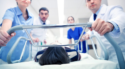 Obraz premium medics and patient on hospital gurney at emergency