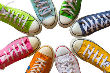 Colorful shoes on white background. Cool youth colorful white yellow green blue black orange gym shoes standing in circle on white background. with copy place top view.