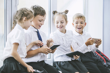 Beautiful children are students together in a classroom at the school receive education with tablets happy