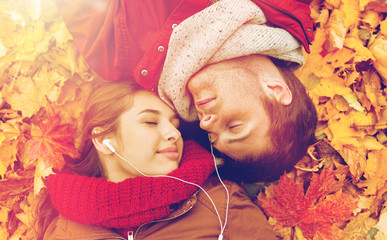 close up of smiling couple lying in autumn park