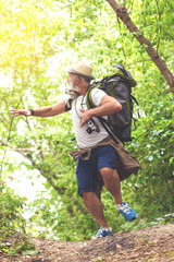 Terrified senior tourist escaping from something in woodland