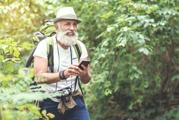 Tired senior tourist searching place of destination with phone