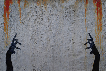 Shadows of two corpse hands on concrete wall with blood drops background. Halloween theme...
