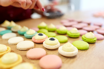 Obraz na płótnie Canvas chef decorating macarons shells at pastry shop