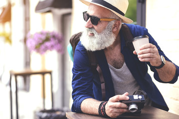 Cheerful mature tourist having break outside